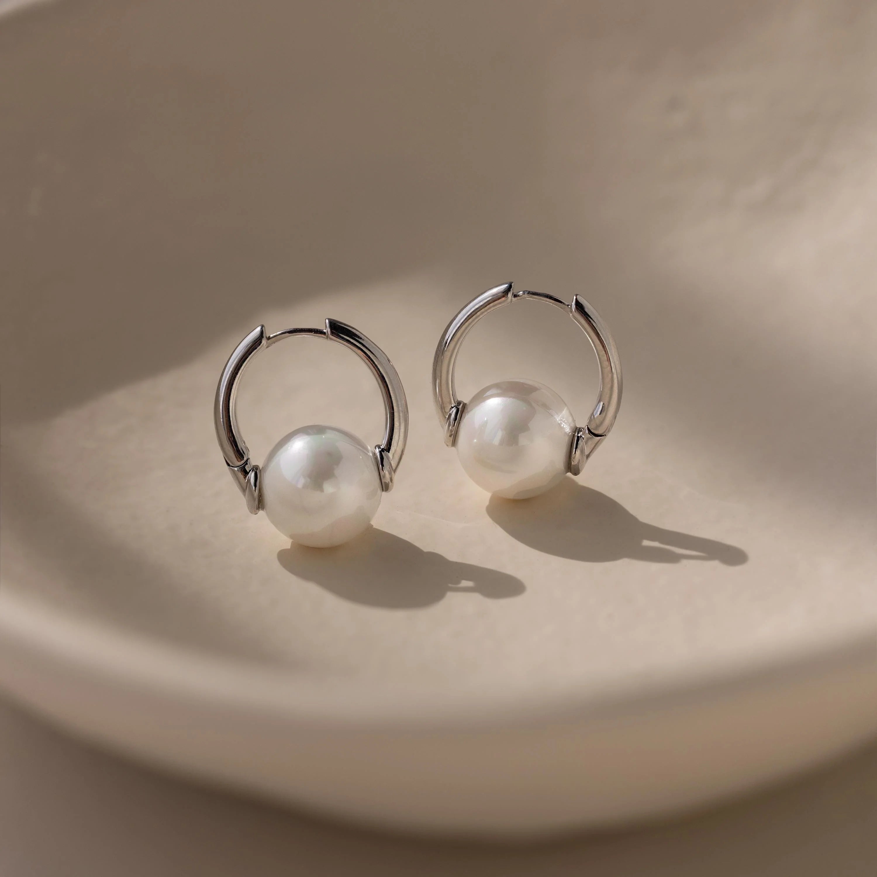 Bold pearl hoop earrings crafted from sterling silver